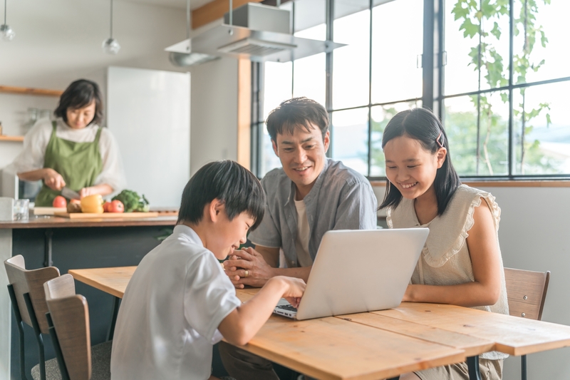 家族の前でPCを楽しむ子ども